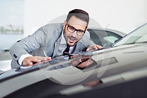 Business man is choosing a new vehicle in car dealership.