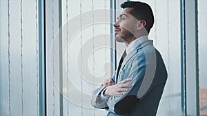 Business man is coming closer to the window. Man is isolated, on white blurred background. Copy space. 4K.