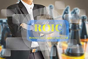 The business man considering the ROIC , Return on invested capital on Virtual screen.