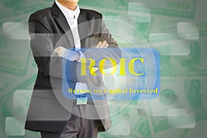 The business man considering the ROIC , Return on invested capital on Virtual screen.