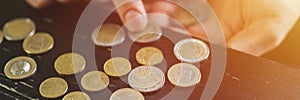 Business man counting money. rich male hands holds and count coins of different euros on table in front of a laptop. banner. flare