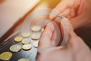 Business man counting money. rich male hands holds and count coins of different euros on table in front of a laptop. flare.