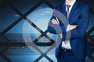 Business man with crossed arms against cityscape background