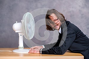 Business man in dark suit sitting in front of ventilator