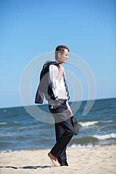 business man dealing with emotional stress walking on the beach