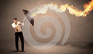 Business man defending himself from a fire arrow with an umbrella