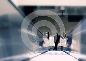 Business man descending down escalator