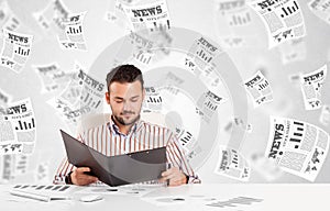 Business man at desk with stock market newspapers