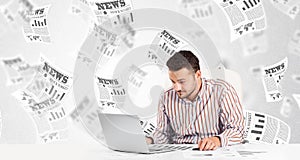 Business man at desk with stock market newspapers