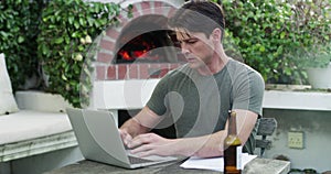 Business man, documents and laptop for remote work from home in garden, reading or typing with beer. Entrepreneur