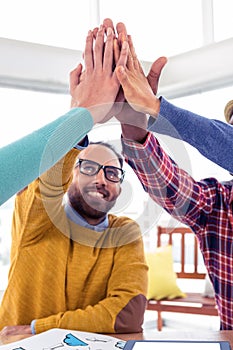 Business man doing high five with team in creative office