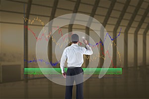 Business man drawing graphics on the screen from the back against indoor background
