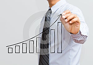 Business man drawing a growing graph