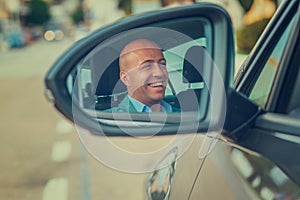 Business man driver in his car looking to the road side view mirror