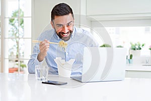 Business man eating asian food from delivery while working using computer laptop at the office