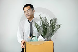 Business man employee stressful resignation from job while picking up personal belongings into brown cardboard