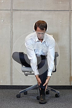 Business man exercising on chair