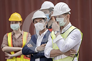 Business man and  Factory workers wearing in a medical mask and safety cloth at outdoor factory cargo warehouse