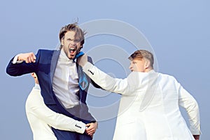 Business man fighting. Group of business people fighting on blue sky background, conflict.