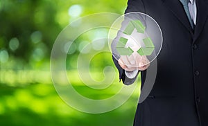 business man finger pointing at paper green recycle symbol with nature background.