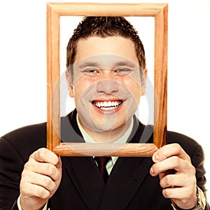 Business man framing his face with wood frame