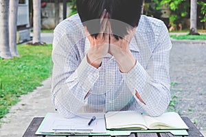 Business man frustrated and ashamed with hands on face at the park,lonely, sad, negative emotions