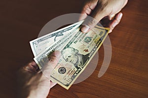 Business man give money bribe concept - person hands man giving money on wooden table background pay cash on delivery pay to