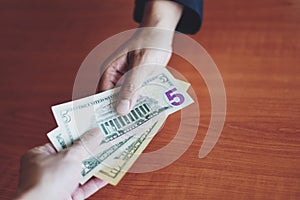 Business man give money bribe concept - person hands man giving money on wooden table background pay cash on delivery pay to