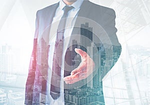 Business man giving hand for handshake , city skyline background