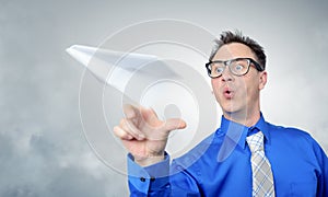 Business man in glasses throwing a paper plane