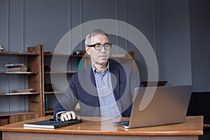 Business man in glasses working from home with laptop