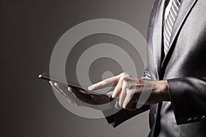 The Business man in Grey suit holding tablet touching social media Technology Concept