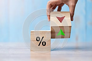 Business man Hand change wood cube block with percentage to UP and Down arrow symbol icon. Interest rate, stocks, financial,
