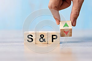 Business man Hand change wood cube block with S&P text to UP and Down arrow symbol icon. Interest rate, stocks, financial, ranking