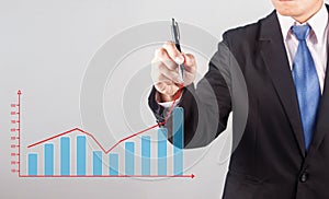 Business man hand drawing a growing graph