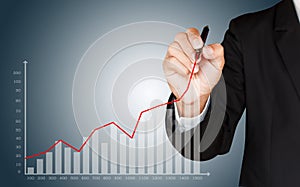 Business man hand drawing a growing graph, representing growth