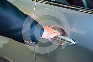 Business man hand holding car doorhandle