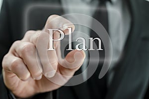 Business man hand pressing Plan button on a touch screen interface