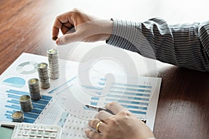 Business man hand putting coin stack for budget Saving money investment and financial accounting management or growing business co