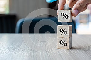 Business man Hand putting wood cube block with percentage symbol icon. Interest rate,  financial, ranking and mortgage rates