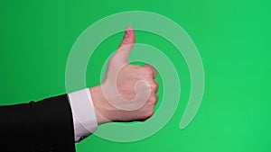 Business man hand showing thumb up on chromakey screen. Hand gestures on a green screen