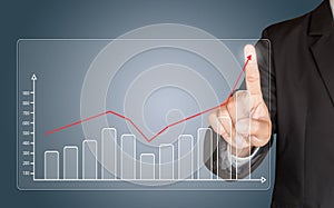 Business man hand touching a graph on blue background