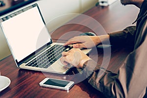 Business man hand using computer laptop in the office with sunlight. Vintage toned filter.