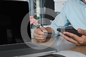 Business man hand using mobile smart phone and credit card  with computer laptop on table.Shop online and make payment