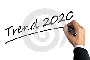 Business man hand writing word trend 2020 with black color marker pen isolated on white background.TRENDS 2020 Business Concept.