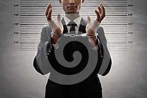 Business man in handcuffs on mugshot background