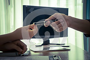 Business man handing pen to a woman for contract signing