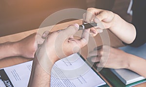 Business man handing pen to a woman for contract signing