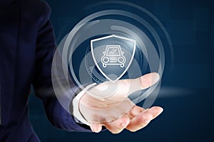 Business man hands holding car and shield icon , car insurance concept