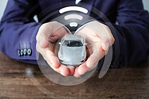 Business man hands holding car and wifi icon , smart car concept